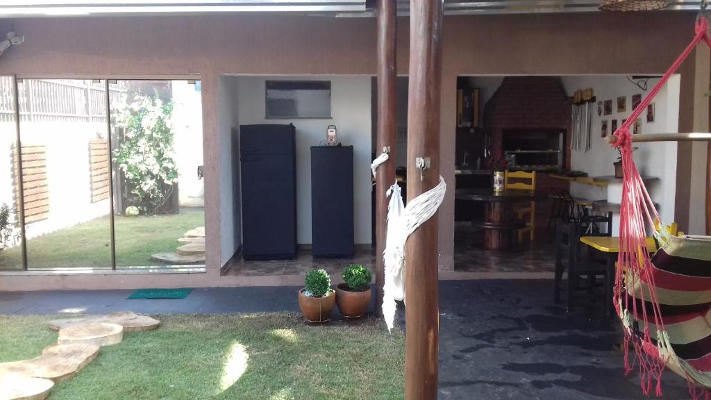 CANTINHO DO SOSSEGO في دورادوس: غرفة مع ساحة بها نباتات الفخار وثلاجة
