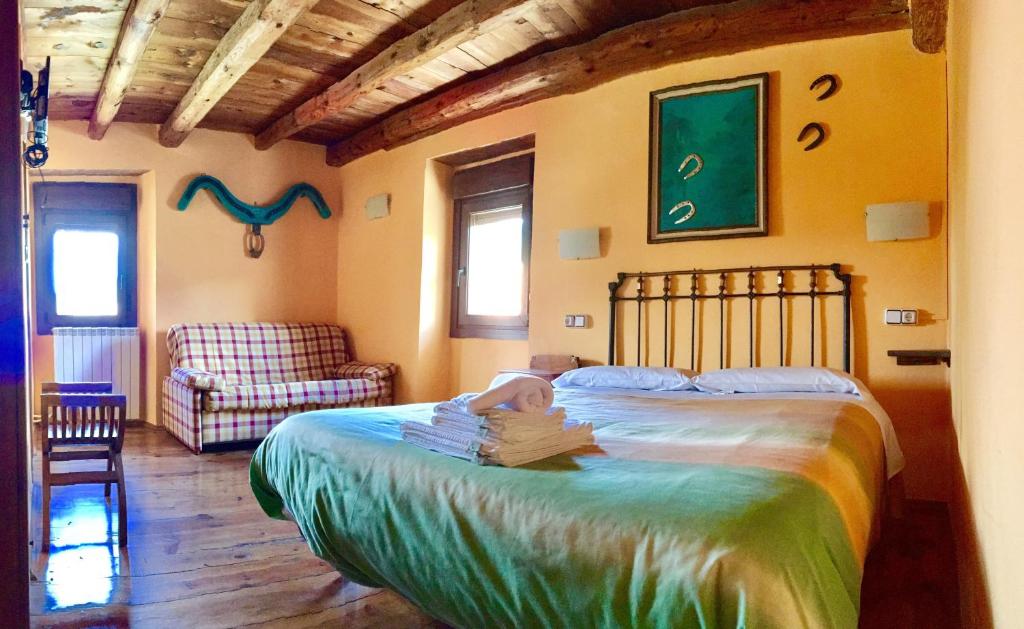 a bedroom with a bed with a child sitting on it at Casa Rural Araceli in Yésero