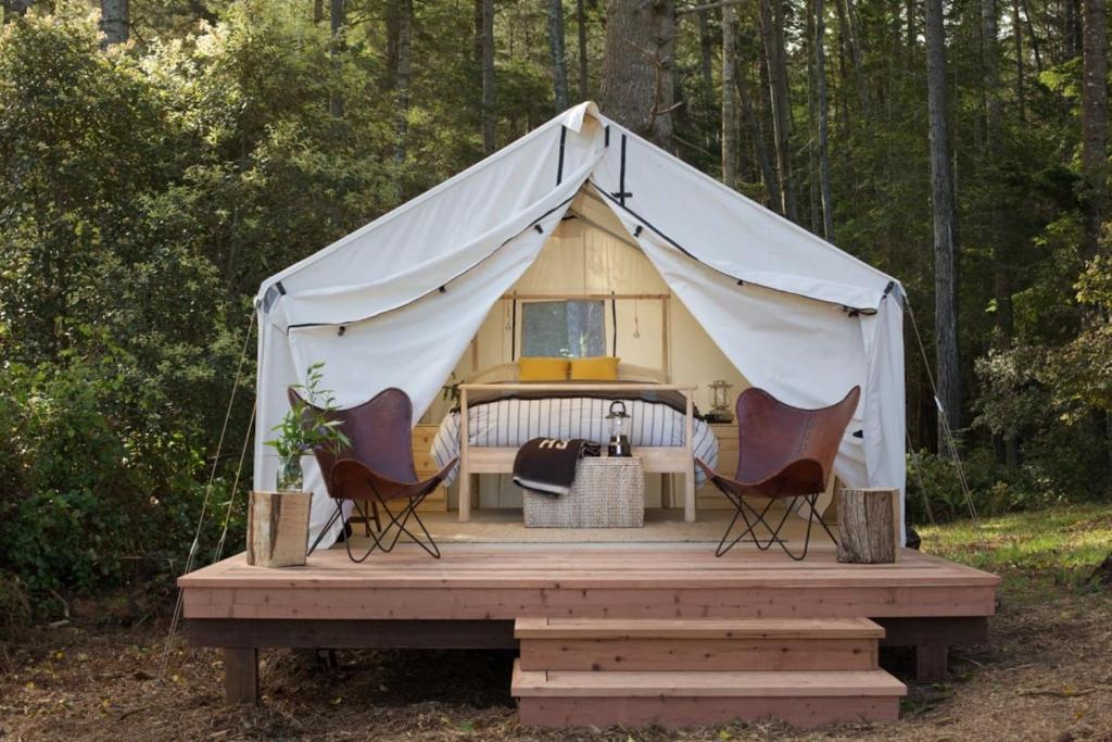 a tent with three chairs on a wooden deck at Mendocino Grove in Mendocino