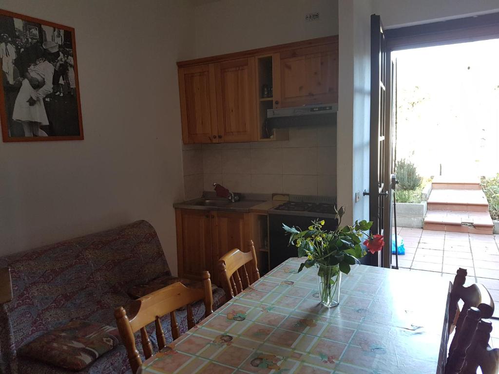 una cucina e una sala da pranzo con tavolo e divano di Domusmare villetta a Capitana