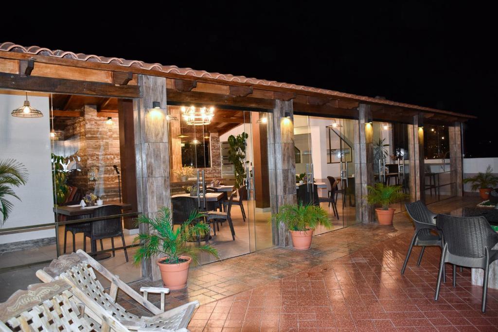 eine Terrasse mit Stühlen und Tischen sowie ein Restaurant in der Unterkunft Hotel San Felipe in Sucre
