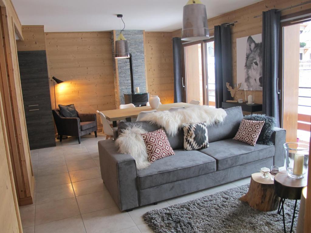 a living room with a gray couch with pillows at Le Bianca 102 Residence l'Epinette in Valloire