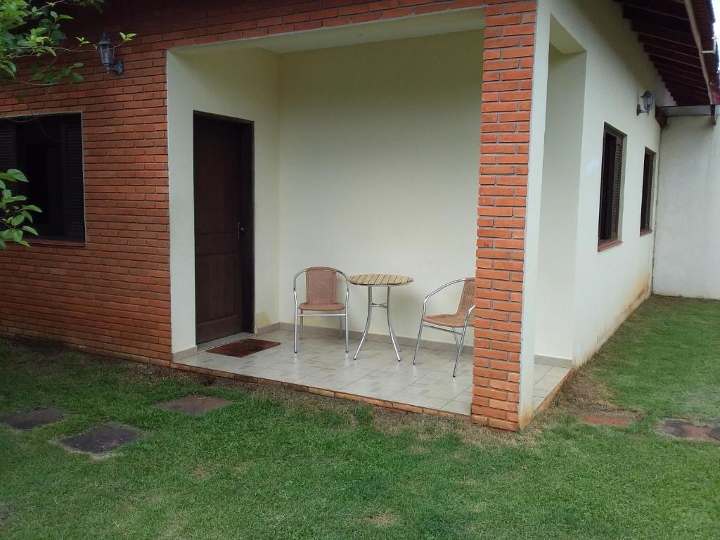 een patio met 2 stoelen en een tafel in een huis bij Seestern Gasthaus in Cananéia