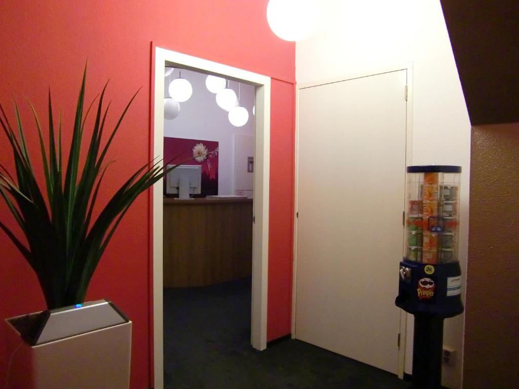 
a small room with a refrigerator and a door at Rembrandt Square Hotel in Amsterdam
