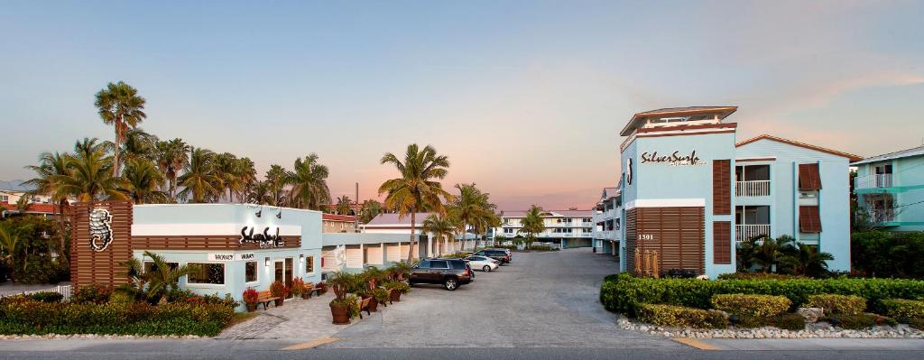 una strada con auto parcheggiate di fronte agli edifici di Silver Surf Gulf Beach Resort a Bradenton Beach