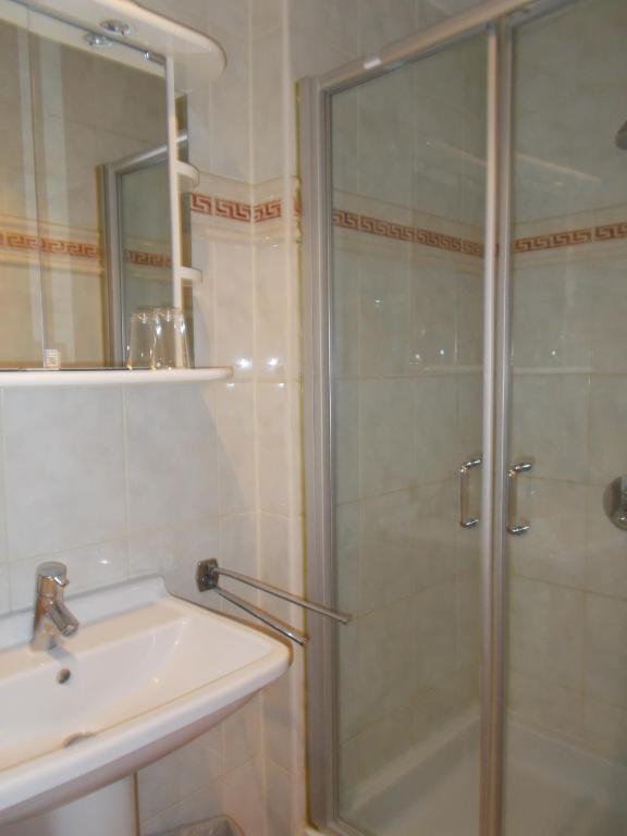 a bathroom with a shower and a sink at Hotel Manitoba in Blankenberge