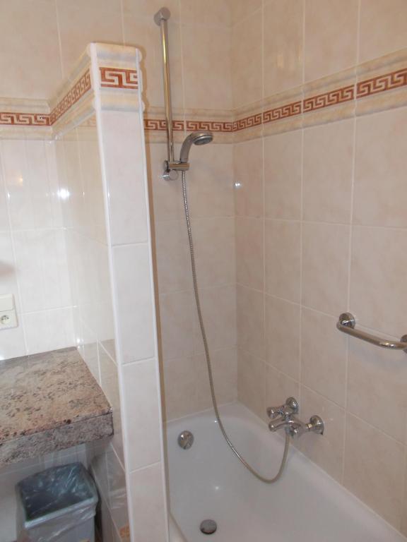 a bathroom with a shower and a bath tub at Hotel Manitoba in Blankenberge