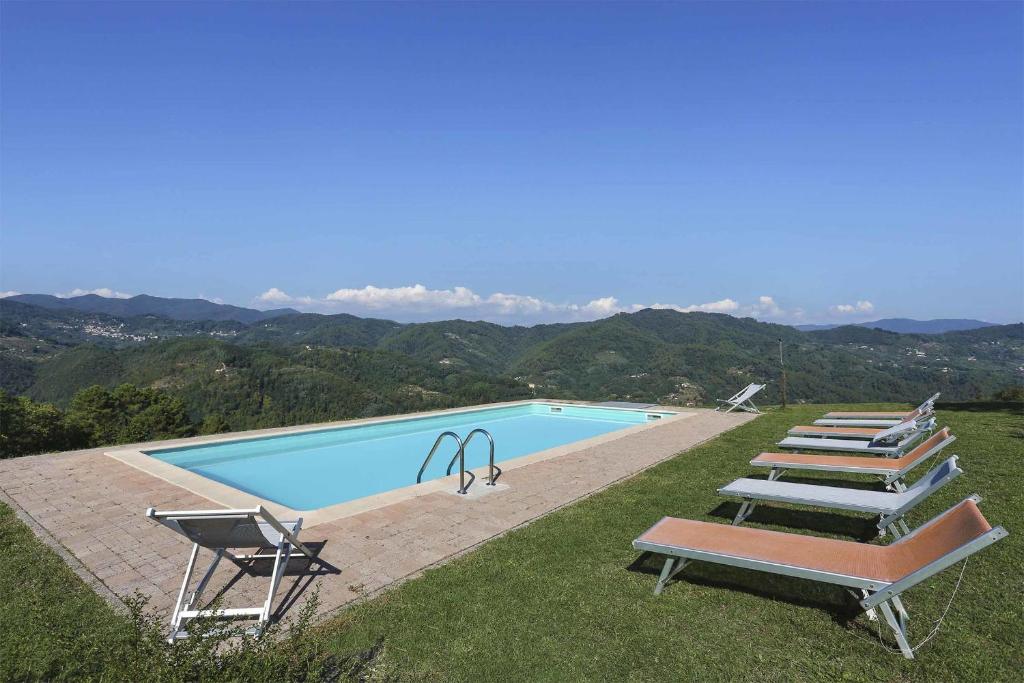 una piscina con un montón de sillas al lado en La Castagnara, en Monsagrati