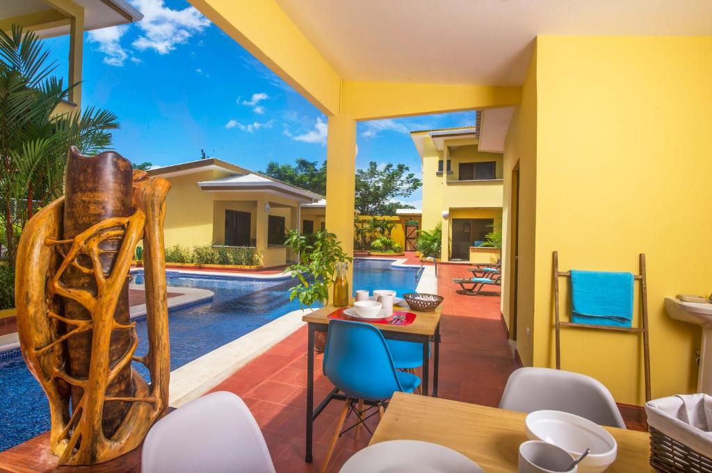 a patio with a table and chairs and a pool at Tamarindo Garden Boutique Homes in Tamarindo