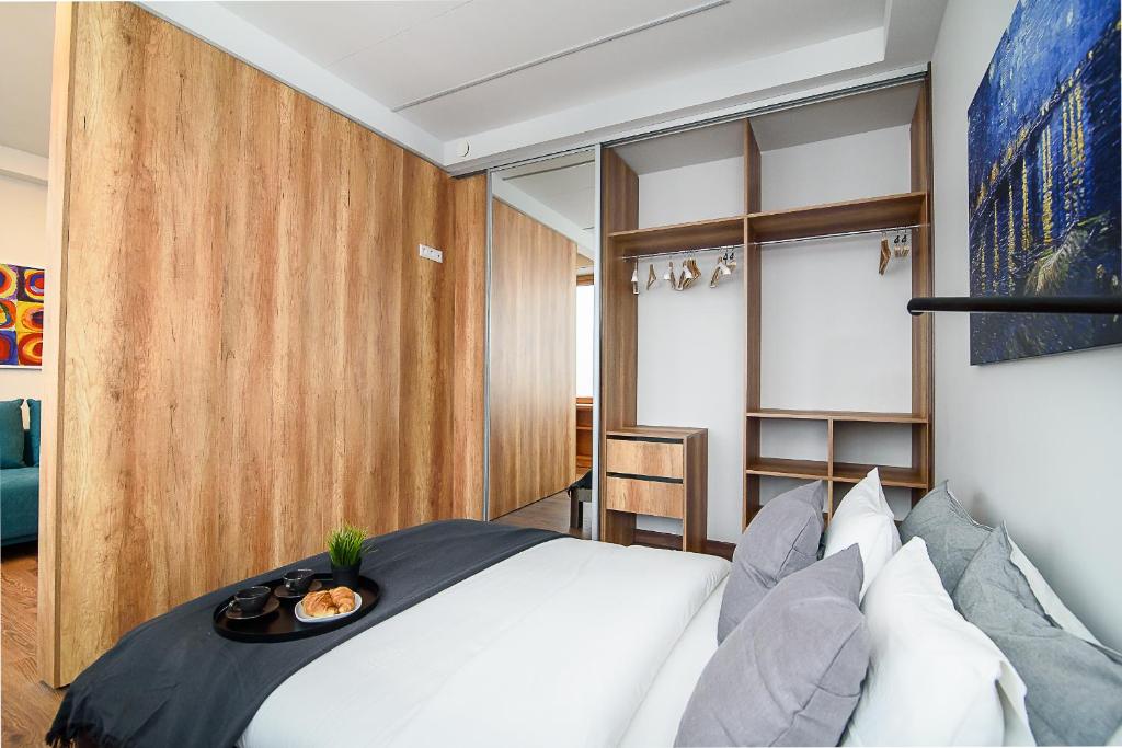 ein Schlafzimmer mit einem weißen Bett und einem Tablett darauf in der Unterkunft Apartment with amazing view! in Vilnius