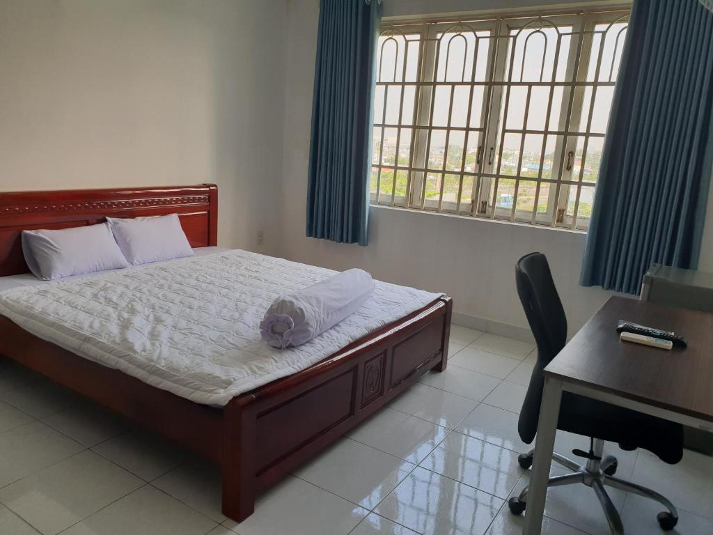 Schlafzimmer mit einem Bett, einem Schreibtisch und Fenstern in der Unterkunft Big room in Ho-Chi-Minh-Stadt