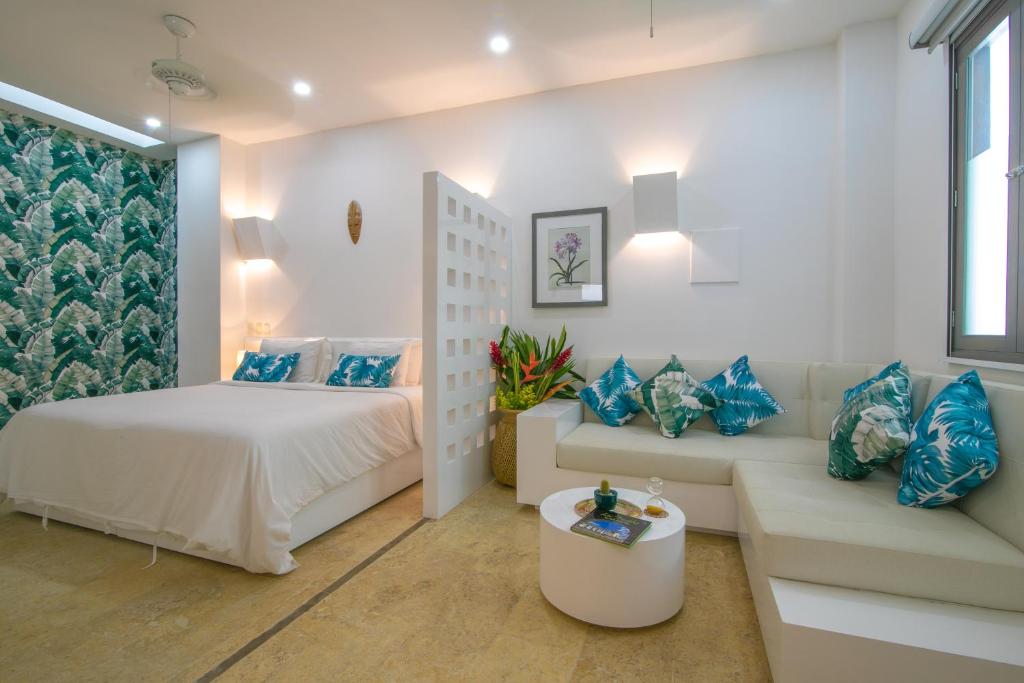 a bedroom with a bed and a couch at El Cactus Luxury Apartments in Historic Center in Santa Marta