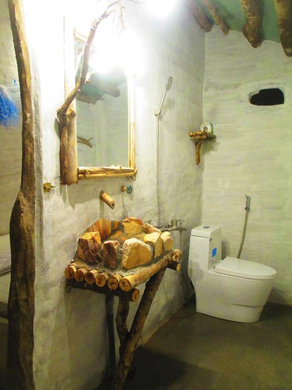 a bathroom with a bed and a toilet and a sink at Phu Nam House - Resort in Phú Quốc