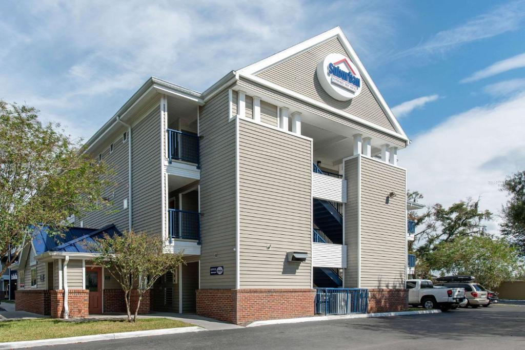 un bâtiment avec une horloge sur son côté dans l'établissement Suburban Studios Lakeland North I-4, à Lakeland