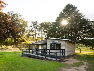 a small house in a field with trees and grass at Dargo River Inn in Dargo