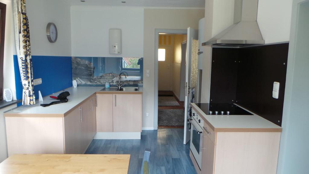 a kitchen with white cabinets and a black refrigerator at Blumenstein Ferienhaus in Kall