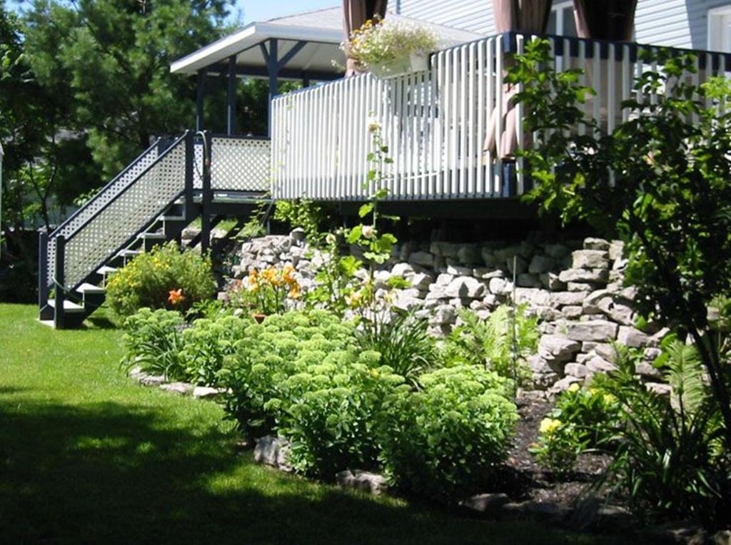 einen Garten mit einer Bank und einem Steinweg in der Unterkunft Gîte Maison Parc Delormier in Trois-Rivières
