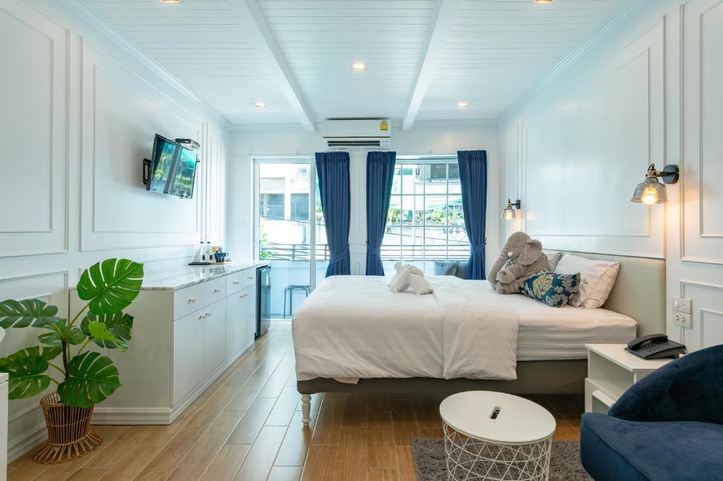 a bedroom with a bed with a teddy bear on it at White Ivory Bed And Breakfast in Bangkok