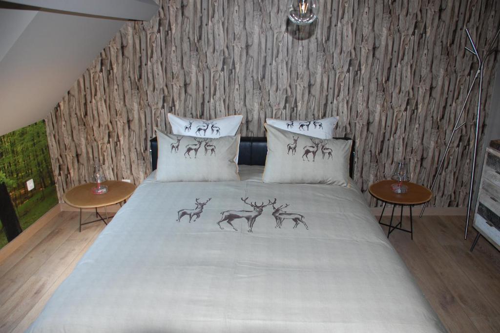um quarto com uma cama com pinturas de veados em Bed & Cook em Aubel