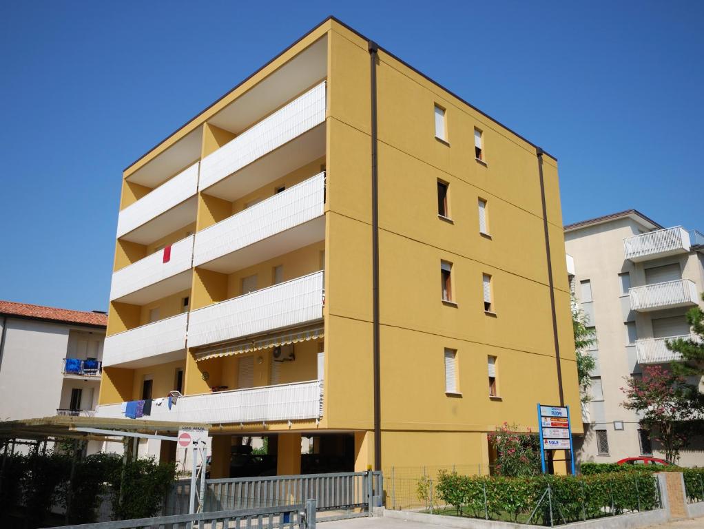 un bâtiment jaune devant certains bâtiments dans l'établissement Condominio Pleione, à Bibione