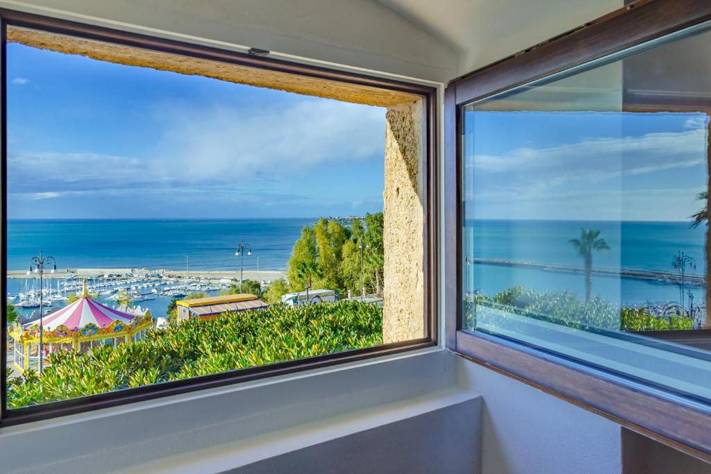 a window with a view of the ocean at Le Maestranze Deluxe Rooms in Sciacca