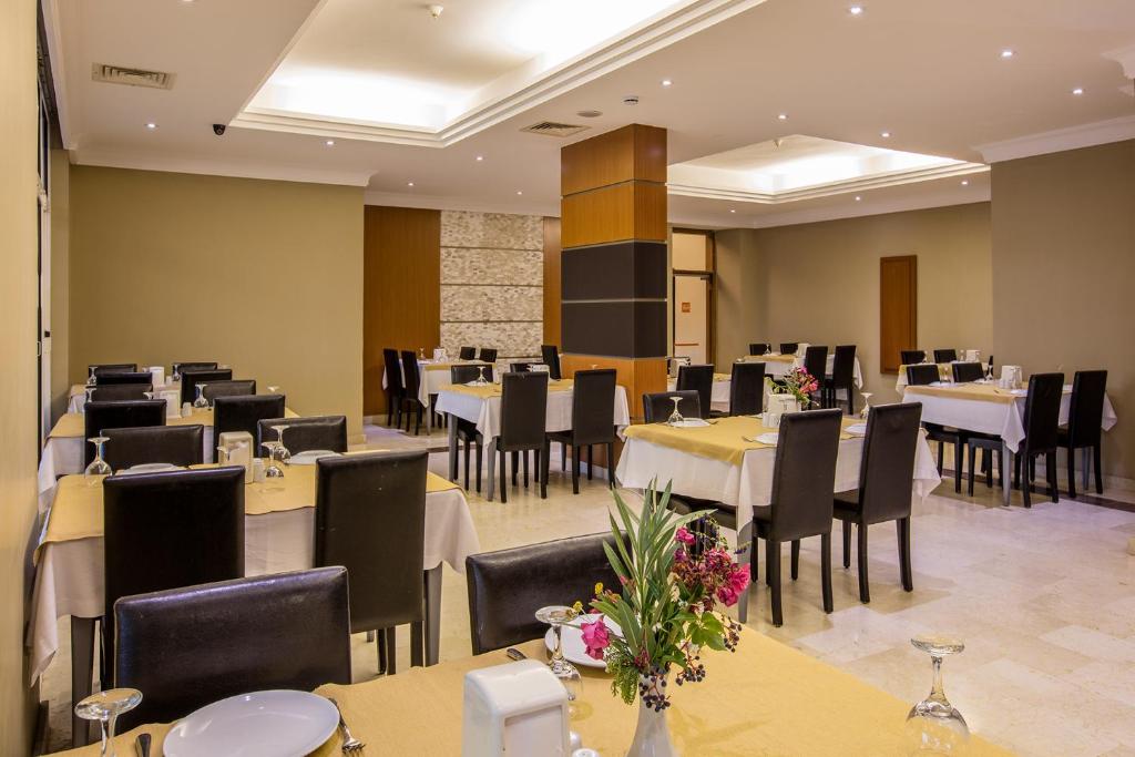 a dining room with tables and chairs and tablesktop at City's Hill Hotel in Kuşadası