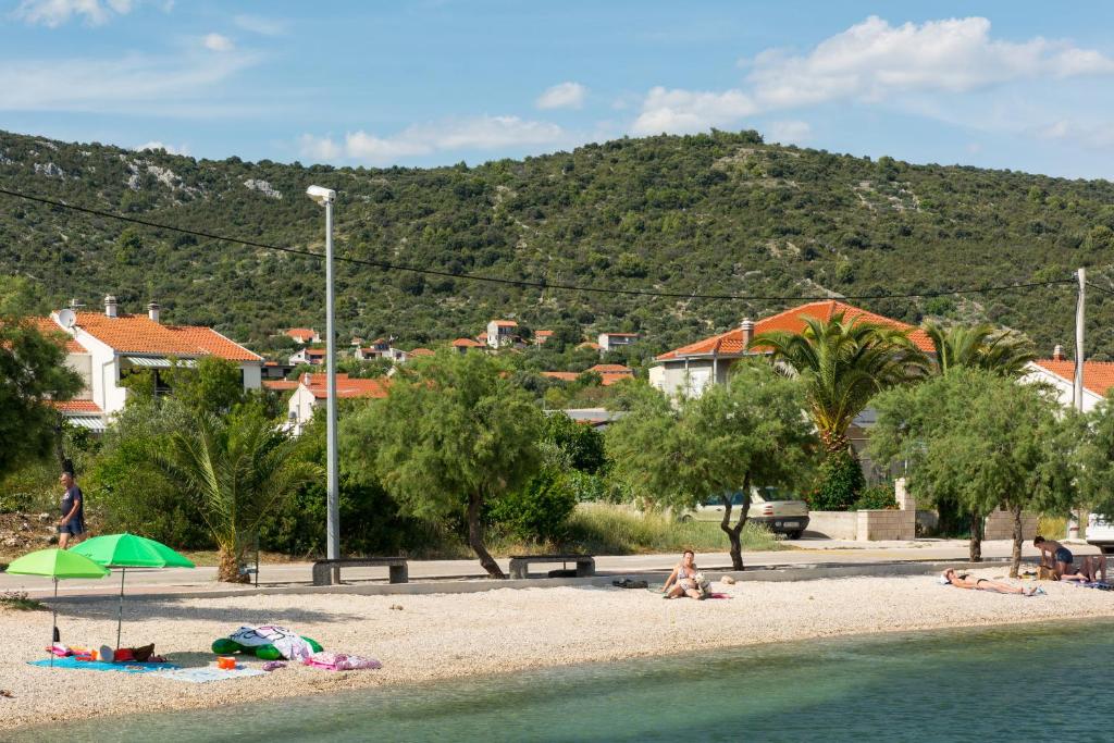 a group of people laying on a beach at Apartmani Stjepan in Vinišće