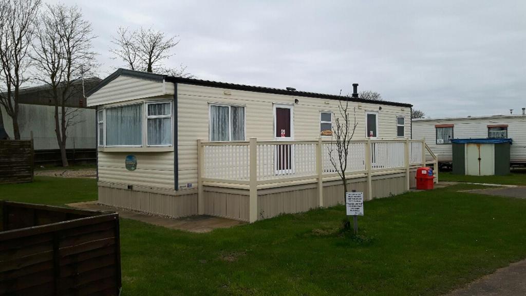 a small house with a fence in a yard at 6 berth on Northshore En-suite Sunnyside in Winthorpe