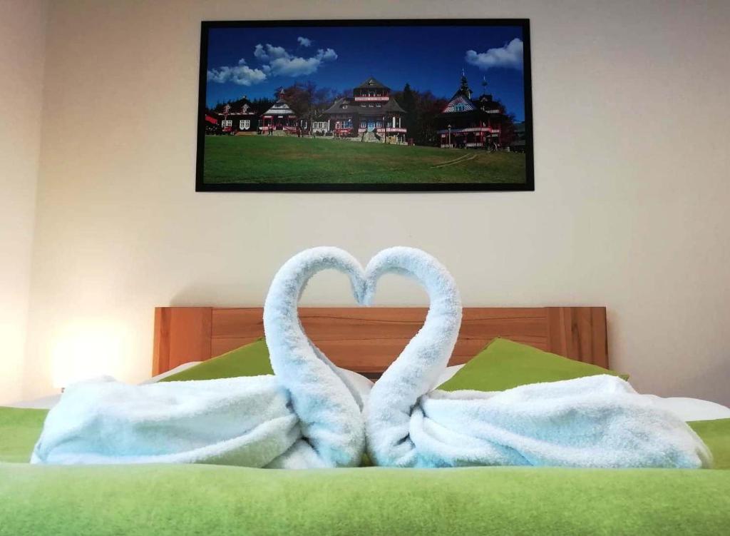 Dos cisnes forman un corazón en una cama en Penzion Adéla, en Rožnov pod Radhoštěm
