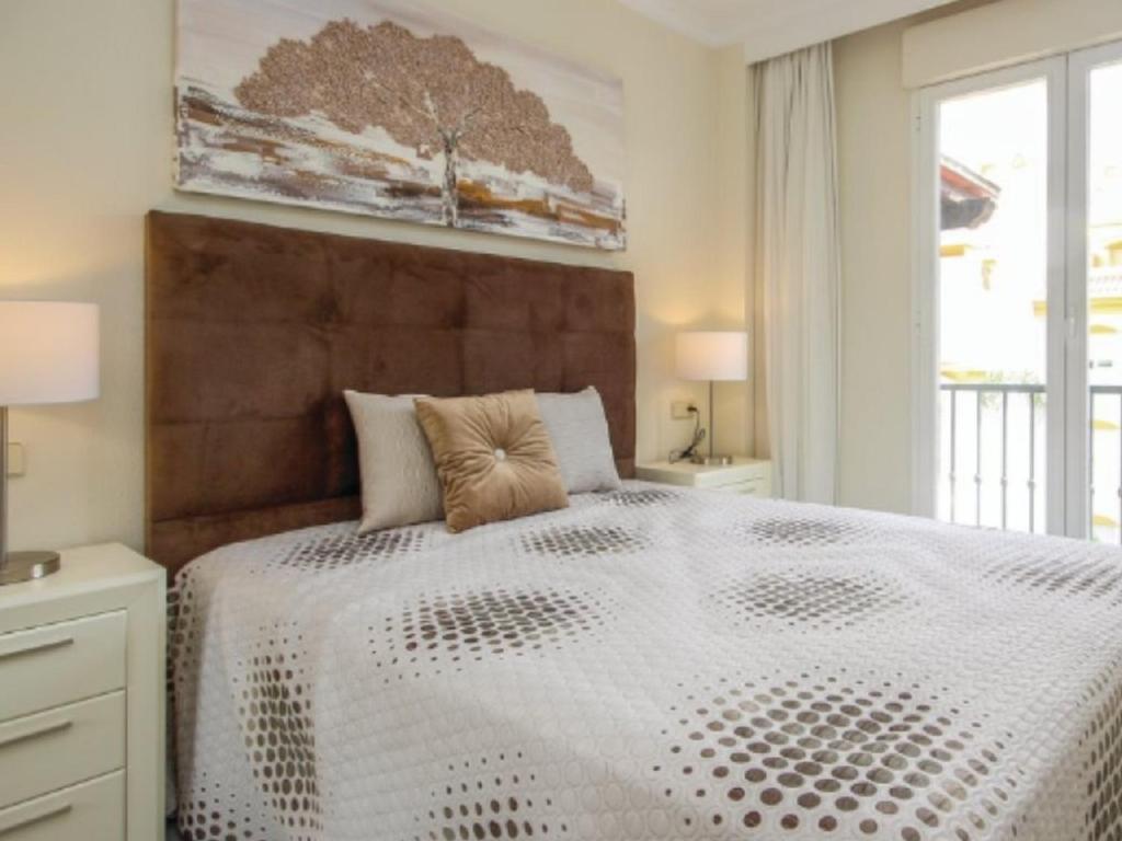 a bedroom with a large white bed with a large window at Dama de Noche in Marbella