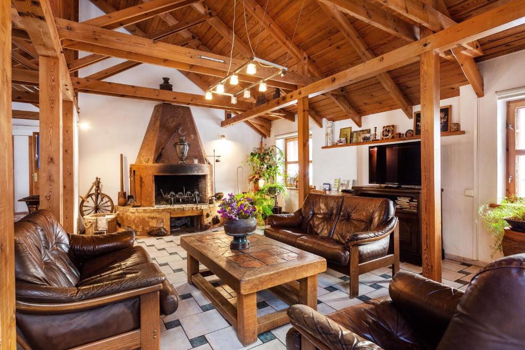 sala de estar con muebles de cuero y chimenea en House of Sun, en Vilna