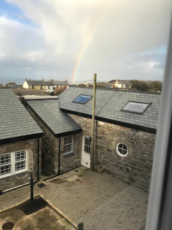 a rainbow over a group of buildings with roofs at The Stables @ The Old Vicarage in Pendeen