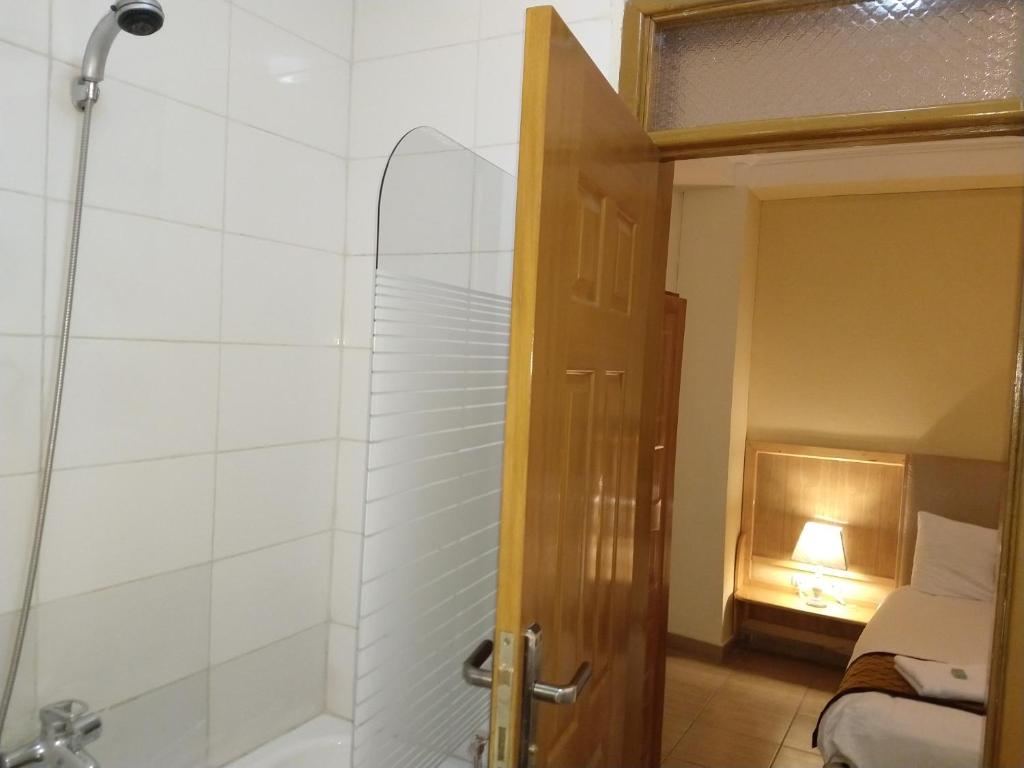 a bathroom with a shower and a glass door at Mekelle Hotel in Mekʼelē