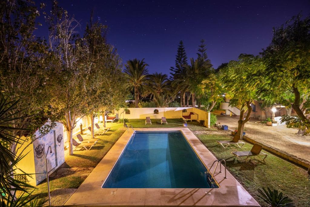 een zwembad voor een huis met bomen bij Paraiso Perdido in Conil de la Frontera