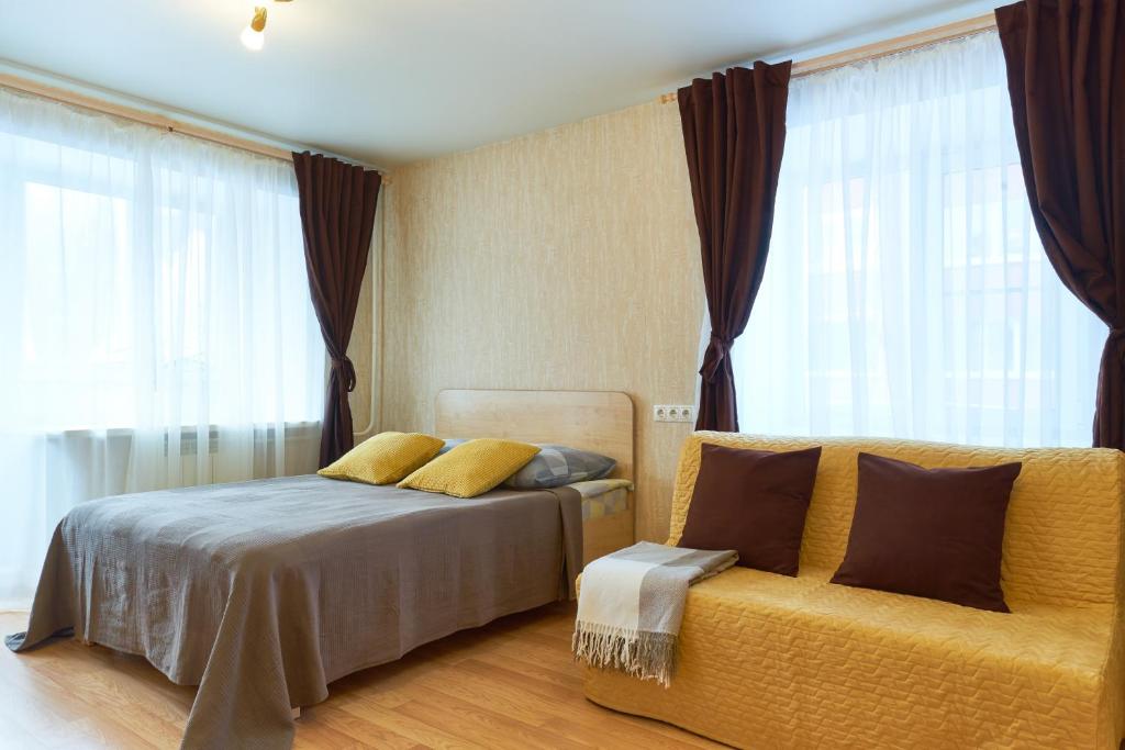 トムスクにある"GOOD NIGHT" on Nikitina 17aのベッドルーム(ベッド1台、黄色のソファ付)
