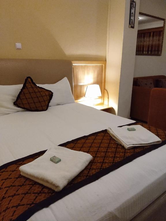 a hotel room with a large bed with towels on it at Mekelle Hotel in Mekʼelē