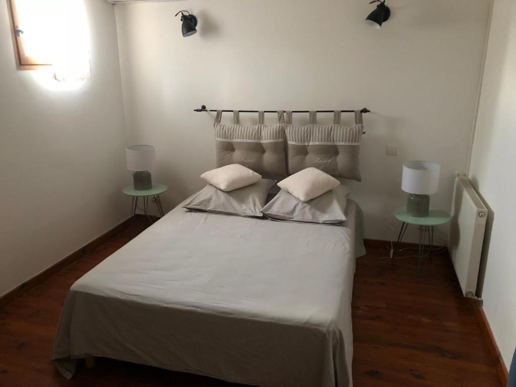 アルトン・デ・パリュにあるVilla valentinaのベッドルーム1室(白い大型ベッド1台、テーブル2台付)