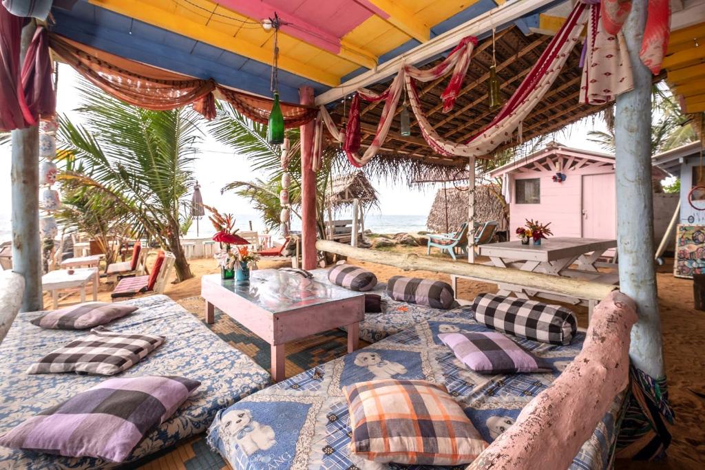 a group of beds on a patio with the beach at Bara Beach Home in Galle