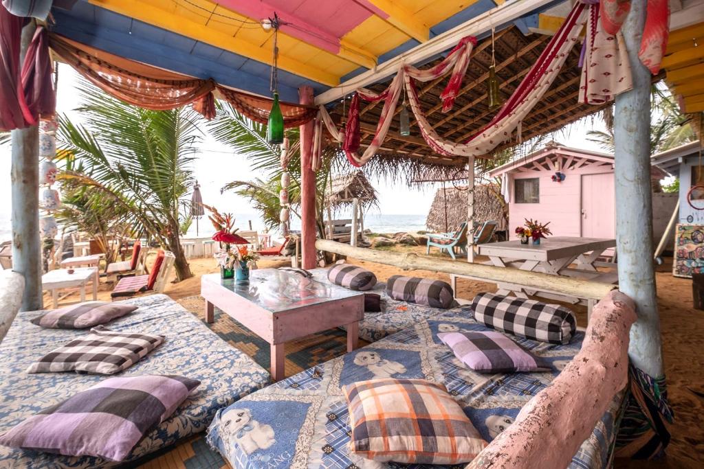 eine Gruppe von Betten auf einer Terrasse mit Strand in der Unterkunft Bara Beach Home in Galle