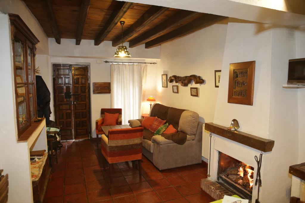 sala de estar con sofá y chimenea en Casa La Tinaja, en Grazalema