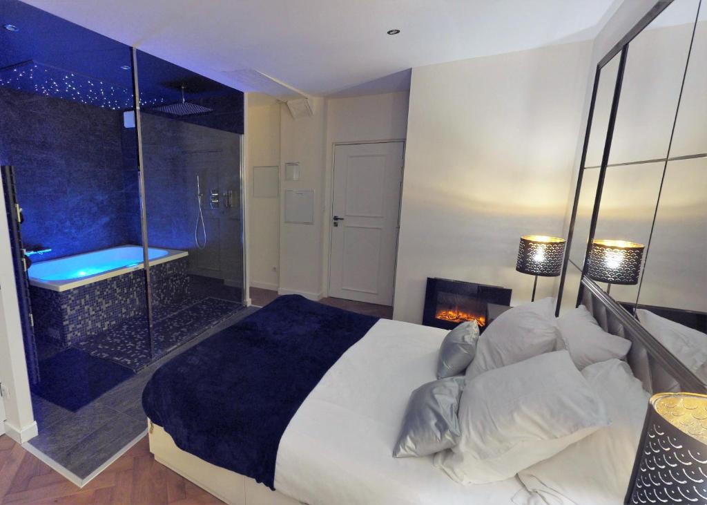um quarto com uma cama, uma lareira e uma banheira em Les Mille et une Nuits em Rouen