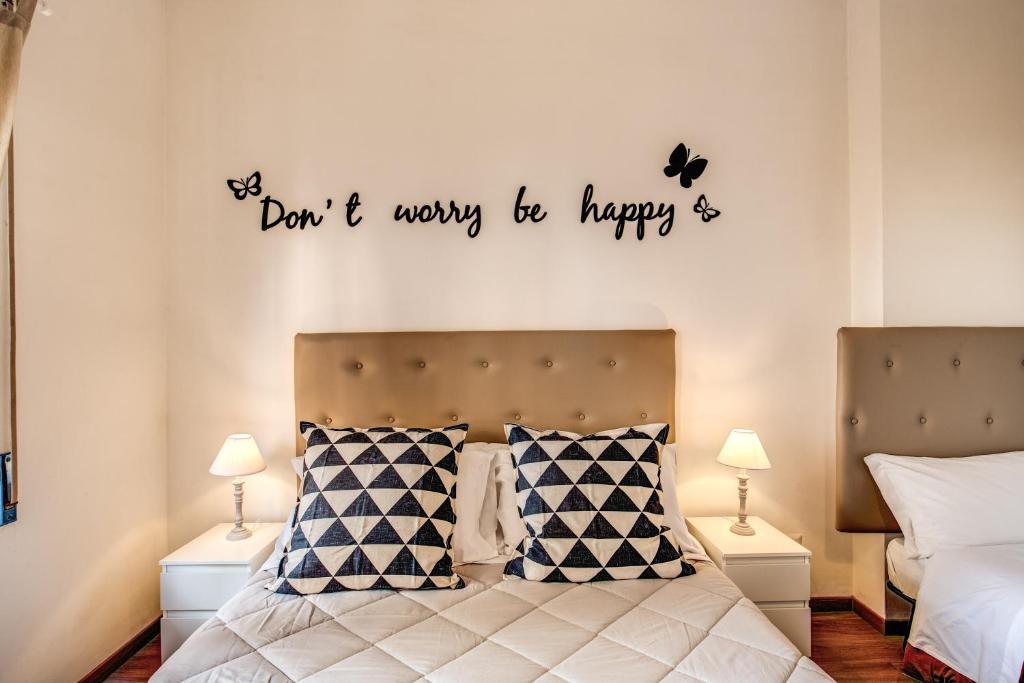 a bedroom with a bed with the words dont worry be happy at Aura Paradise Apartment in Rome
