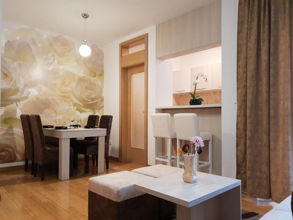 a dining room with a table and a painting on the wall at Apartman KEJ free parking in Kraljevo