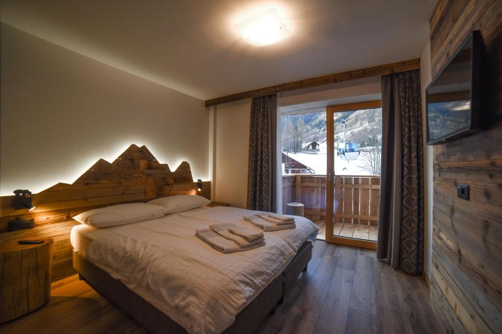 una camera da letto con un grande letto con asciugamani di Residence & Wellness 3MILA a Peio Fonti