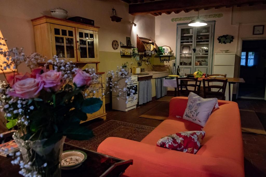 - un salon avec un canapé orange et un vase de fleurs dans l'établissement La casa rosa, à Vitiano