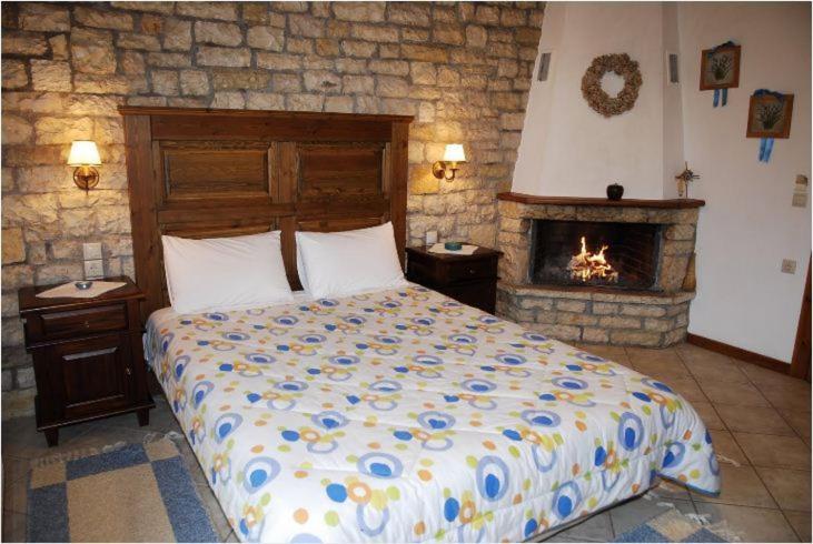 1 dormitorio con 1 cama y chimenea en Petrino, en Méga Khoríon