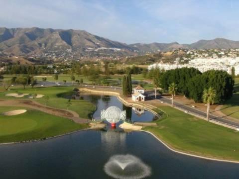 einen Luftblick auf einen Golfplatz mit See in der Unterkunft Valleverde Apartment in Mijas Costa