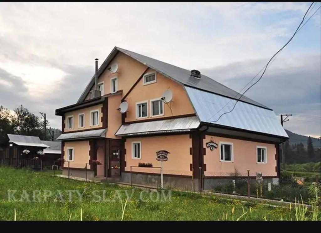 una grande casa con tetto in metallo di "Різьбярська садиба" a Slavske