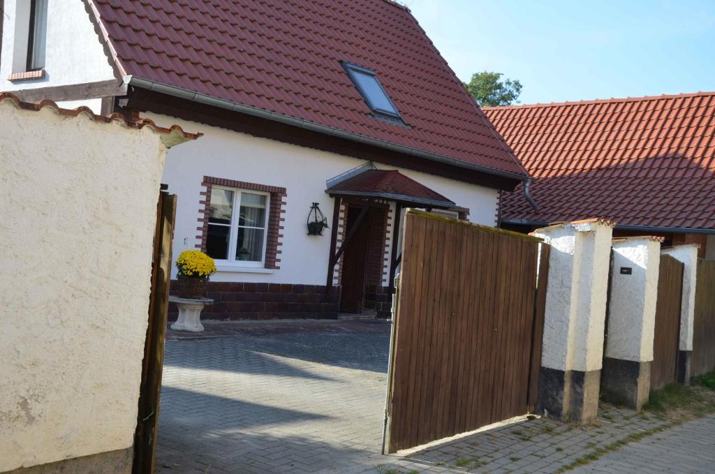 una puerta de madera a una casa con techo rojo en Ferienhaus Spreewiese, en Schlepzig