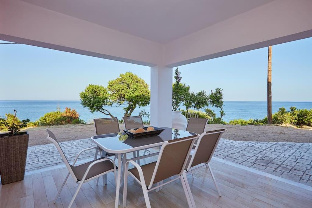 a dining room with a table and chairs and the ocean at Chioni's Houses in Chios